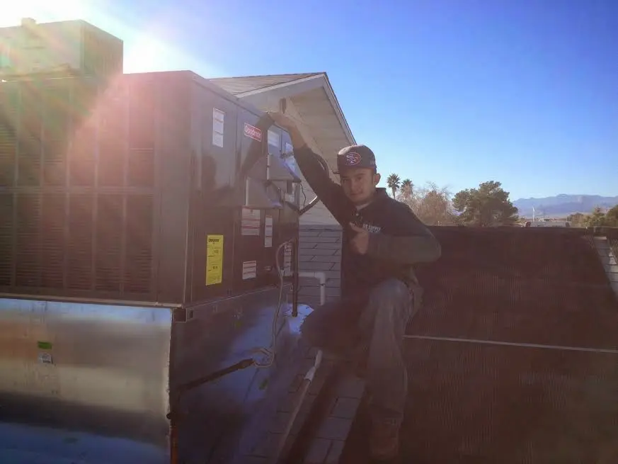 HVAC technician performing AC Tune-Up on a rooftop unit in Chesterland